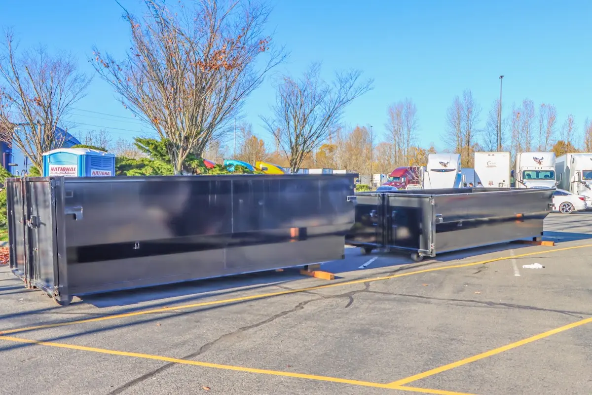 Professional dumpster rental service with roll-off container on residential driveway in Henrietta